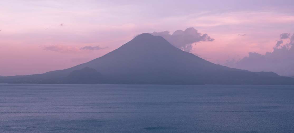 A mountainous island in a lake surrounded by mist.